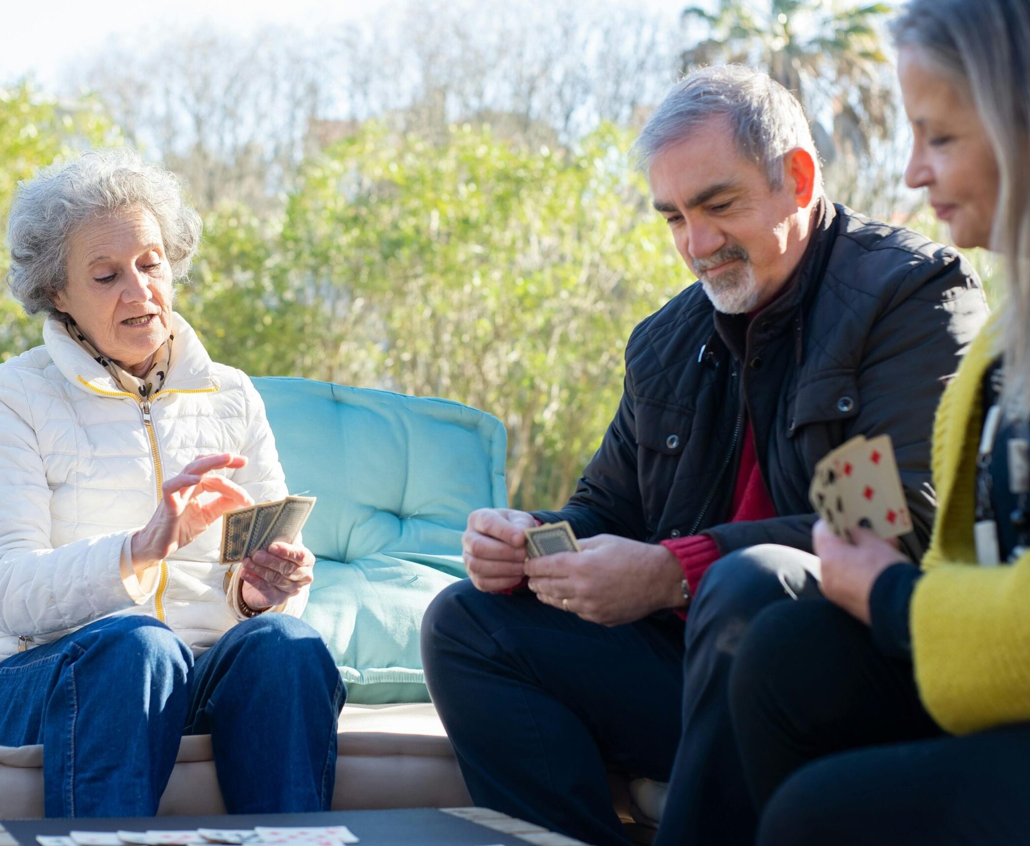 Group of elderly people playing a card game in a Senior Care Facility.